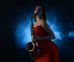 Professional musician playing saxophone on dark background with blue light and smoke