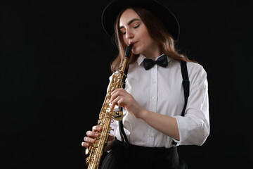 Musician playing soprano saxophone on dark background