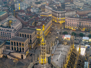 Fototapeta premium Night aerial drone view of illuminated Milano Duomo spire statue