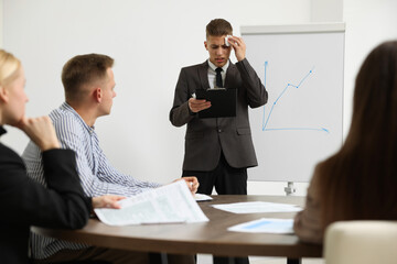 Glossophobia. Man with paper tissue and clipboard feeling embarrassed during business meeting in...