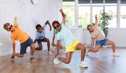 African girlie perform movements during warm-up, limbering-up part of workout with peers. Group of...