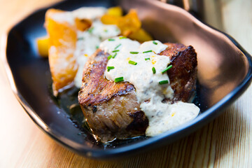 Appetizing veal sirloin steak with baked potatoes and creamy mushrooms sauce..