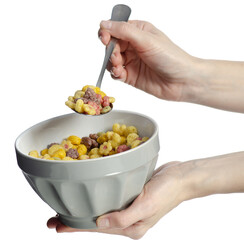 Hand holding a colorful breakfast cereal in white bowl with spoon on white background isolation