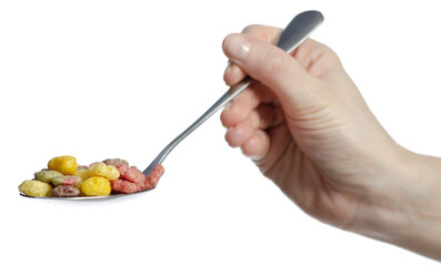 Hand holding spoon with colorful breakfast cereal on white background isolation