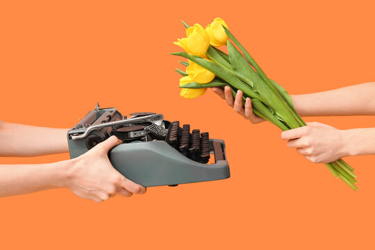 Female hands with retro typewriter and tulip flowers for International Women's Day on color background, closeup