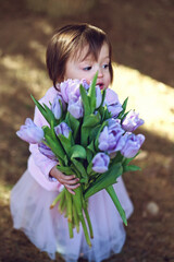 Little girl with purple tulips