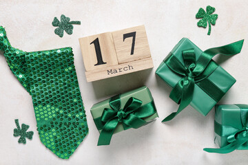 Gift boxes with calendar, tie and clovers for St. Patrick's Day celebration on white grunge...
