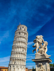 Leaning Tower of Pisa and statue of small cupids against the sky