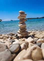 Stones stacked in a pyramid on the seashore on a sunny summer day