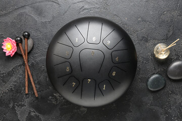 Glucophone with sticks, spa stones and reed diffuser on grunge black background