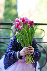 Little girl with purple tulips