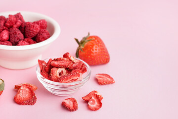 Bowl with freeze-dried strawberries on pink background