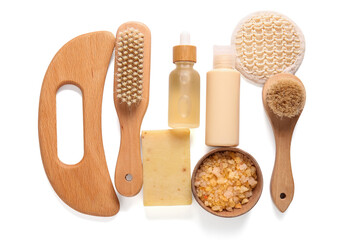 Beautiful composition with wooden guasha body massage tool and bottles of cosmetic product on white background