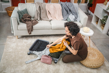 woman sit on floor and pack suitcase baggage prepare for vacation