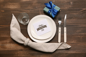 Festive decorated table setting with gift box on dark wooden background. Father day celebration...