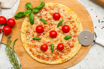 Tasty pizza, cutter and ingredients on light background