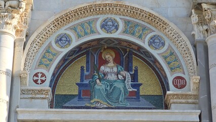 Pisa, Italy. December 30, 2024: A detailed mosaic above an arched entrance, depicting a haloed...