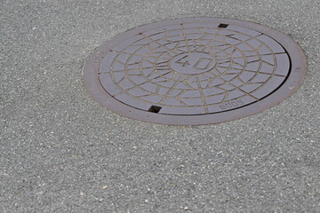 Round Manhole Cover on Asphalt Road