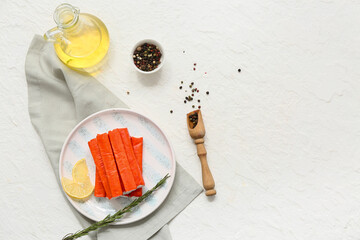 Plate with tasty crab sticks, slices of lemon and rosemary on white background © Pixel-Shot