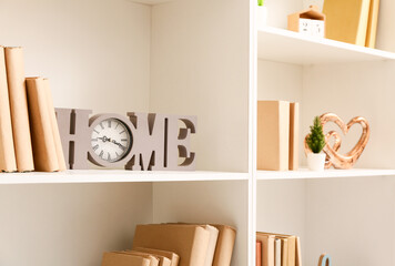 Shelves with books and stylish decor, closeup