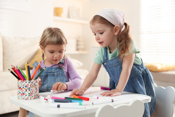Fototapeta premium Cute little sisters drawing at white table in room
