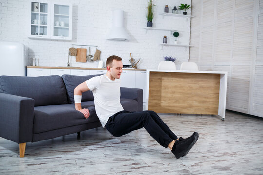 This is a home fitness routine featuring a young man performing tricep dips on a sofa, set in a modern living room environment. It emphasizes the importance of maintaining an active lifestyle - Powered by Adobe