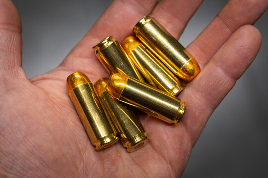 Powerful .50 AE caliber pistol cartridges in a man's palm.