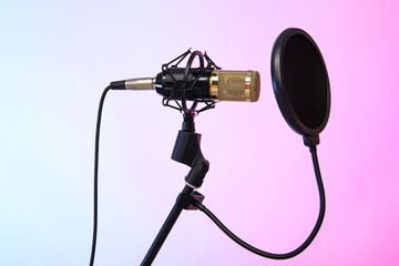 Stand with professional microphone on color background