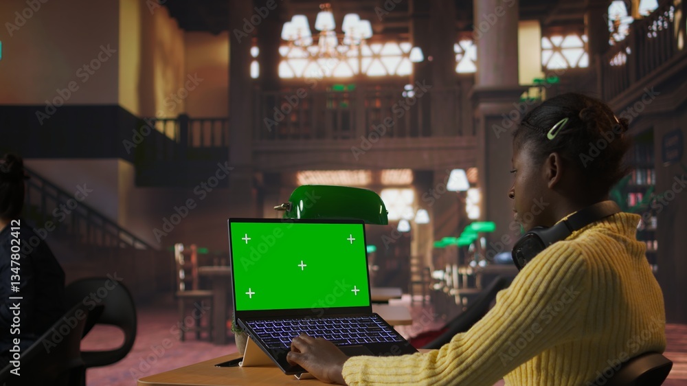Poster black scholar reading information via internet next to chroma key in a library, focusing on theoreti