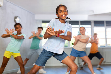 Young boys and girls performing dance with his mates in studio during rehearsal.