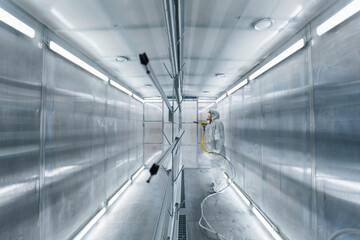 man painting parts in powder coating booth