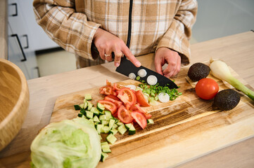 Person Preparing Fresh Vegetables for a Healthy Salad in a Kitchen