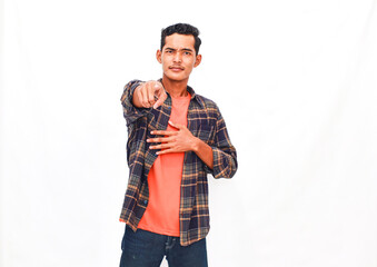 Expressive young man in casual clothing points directly towards the camera lens