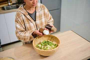 Woman Preparing Fresh Salad in a Cozy Home Kitchen Setting