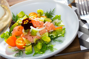 Salmon ceviche with avocado, kumquat and dill served on plate