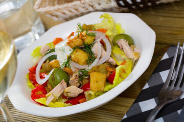 Bowl of delicious salad with grilled chicken, eggplants and greens