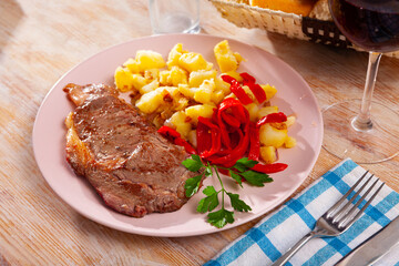 Tasty veal baked with potatoes and peppers served at plate, nobody