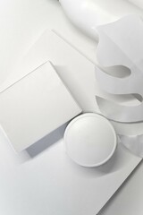 Mockup of a white box, white palm leaf and jar on a white background 