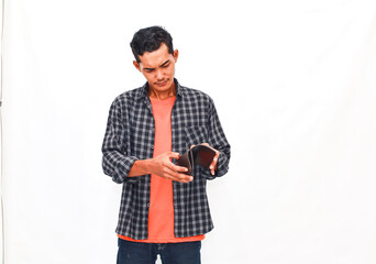 Fototapeta premium A Person Examining An Empty Pocketbook Against A Plain Background