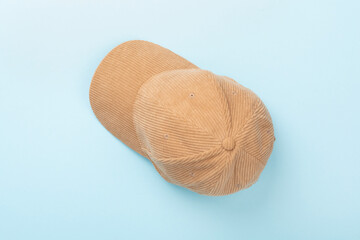 Beige velvet cap on color background, top view