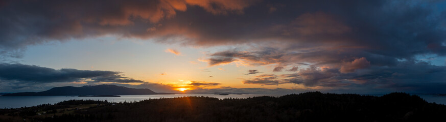 Aerial view of a dramatic sunset behind Orcas Island in the San Juan Islands archipelago. Looking across Rosario Strait this colorful sunset is seen from Lummi Island, Washington state.