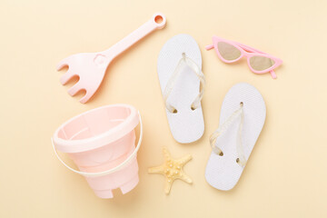 Children's flip flops and beach toys on color background,,top view
