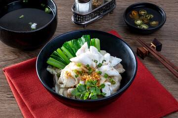 chinese egg noodle in bowl with slice red roasted pork, pork's wontons and white crab meat on it.