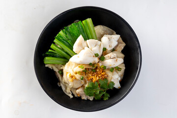 chinese egg noodle in bowl with slice red roasted pork, pork's wontons and white crab meat on it.