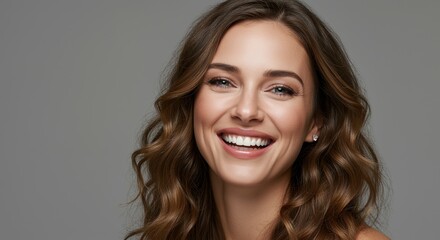 Naklejka premium A joyful woman with wavy brown hair flashes a bright smile, showcasing her perfect teeth and vibrant personality, capturing the essence of happiness and beauty.