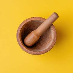 wooden mortar and pestle on bright yellow background, perfect for grinding spices and herbs. This kitchen tool adds rustic touch to culinary activities