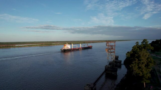 Barco mercante pasando por el r&iacute;o Paran&aacute; en Rosario durante un atardecer. Comercio, importaci&oacute;n, exportaci&oacute;n