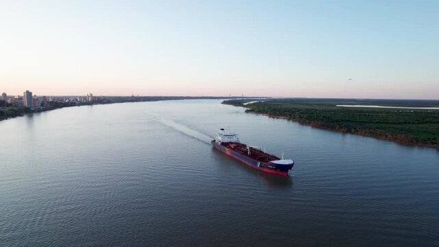 Barco mercante pasando por el r&iacute;o Paran&aacute; en Rosario durante un atardecer. Comercio, importaci&oacute;n, exportaci&oacute;n