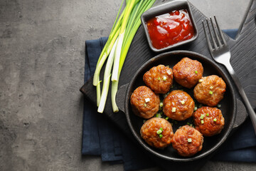 Tasty meatballs in baking dish served on grey table, flat lay. Space for text