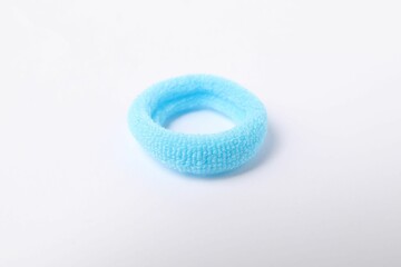 One blue hair tie on white background